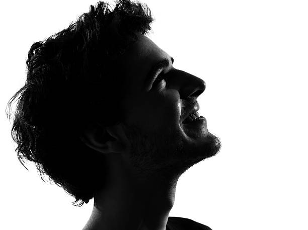 junger mann silhouette glücklich similing - profil stock-fotos und bilder