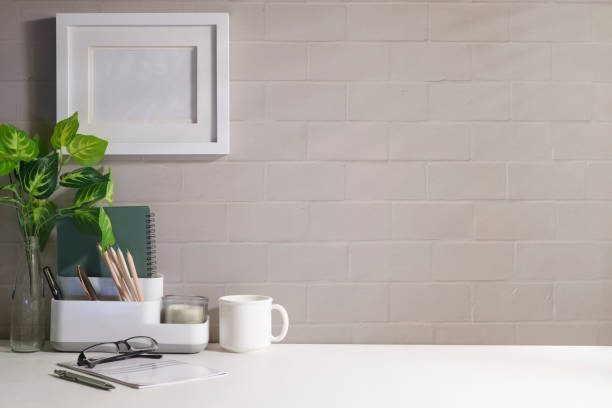 istock Comfortable workplace with picture frame, coffee cup, notebook and house plant. Home office desk, Copy space for your text. 1429226056