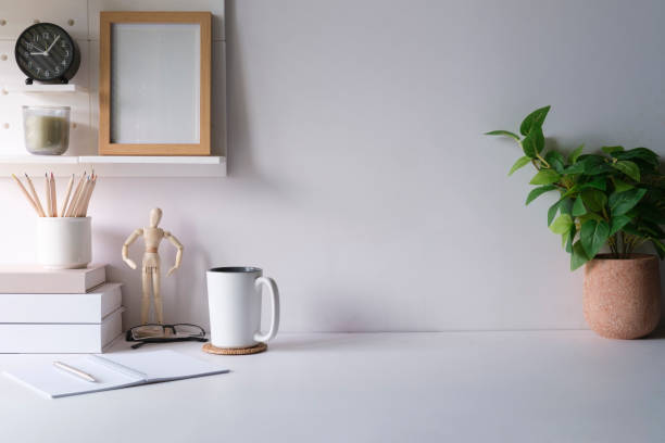istock Comfortable workplace with houseplant, picture frame, coffee cup and stationery on white table. 1429226468