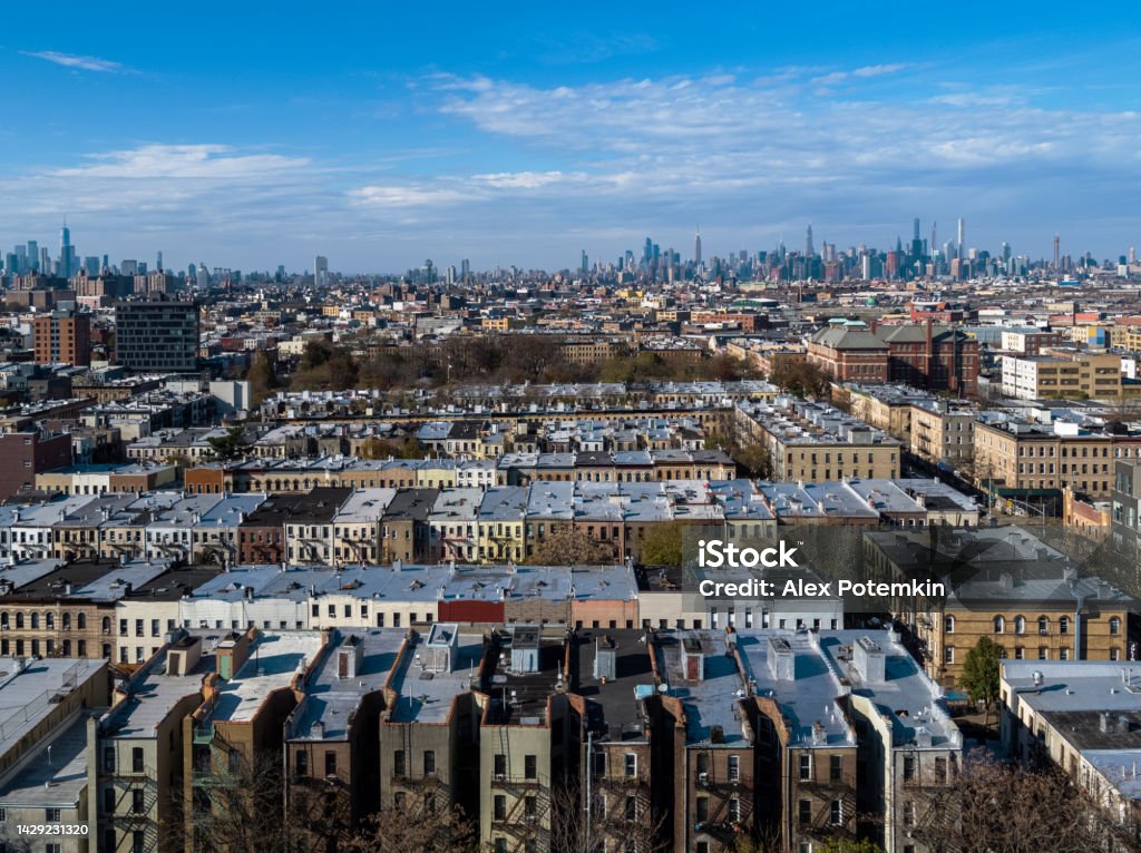 Residential district in Bushwick, Brooklyn, New York, in the sunny afternoon, with the remote Manhattan in the backdrop. Aerial view of the residential areas of Brooklyn, New York, USA. New York City Stock Photo