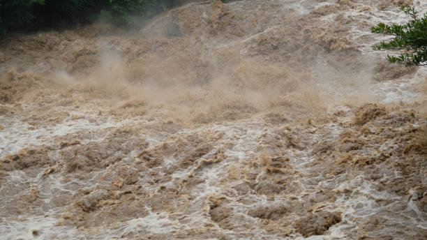 istock Waterfall cataract in forest mountains. Dirty streams are flowing down the mountain slopes of the mountain forest after heavy rains in Thailand. River flood, selective focus. 1429247726