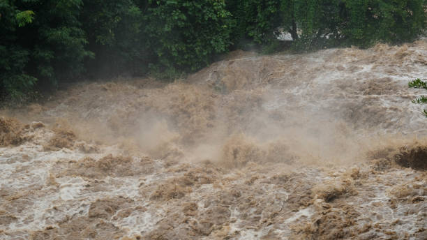 istock Waterfall cataract in forest mountains. Dirty streams are flowing down the mountain slopes of the mountain forest after heavy rains in Thailand. River flood, selective focus. 1429247730