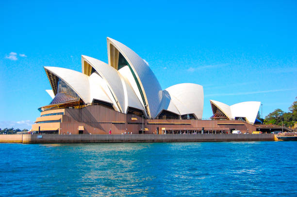 sydney opernhaus australien mit blauem himmelshintergrund. - sydney opera house stock-fotos und bilder