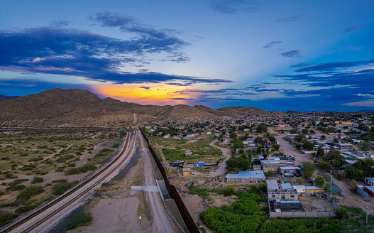 The sun sets in Puerto de Anapra town at the border between USA and Mexico - drone view