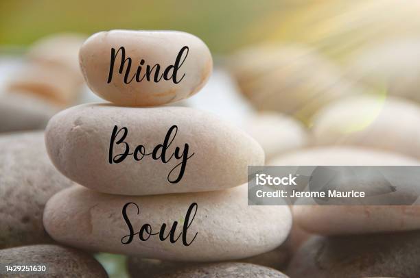 Light Shining On Zen Stones With Words Mind Body Soul On Blurred Background Customize Space For Text Or Ideas Stock Photo - Download Image Now