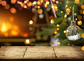 暖炉とクリスマスの装飾品の背景に空の木製のテーブル。スペースをコピーします。