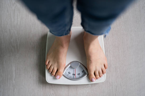 istock Scale Woman Feet Standing On Weight Scale In Bathroom 1429256261