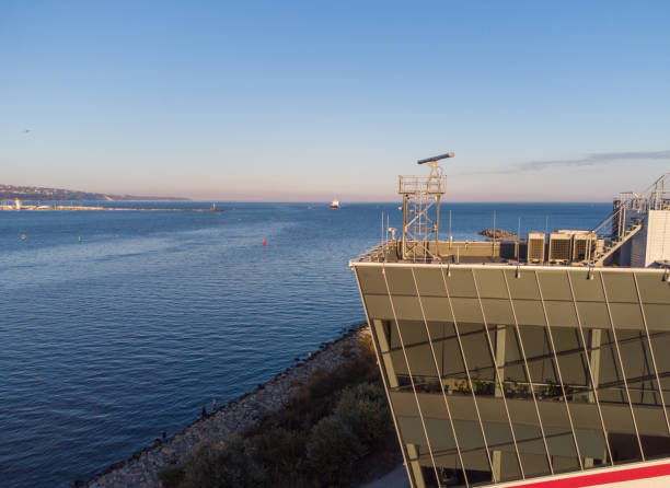 control tower of ships with big cargo ship entering the port at the evening - sea safety antenna radar imagens e fotografias de stock