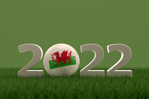 3d rendering of soccer ball with Wales flag on a grass field.  .