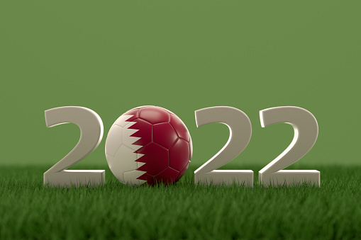 3d rendering of soccer ball with Qatar flag on a grass field.  .