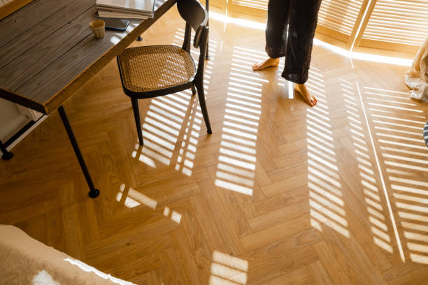 Woman walks on wooden parquet at home stock photo