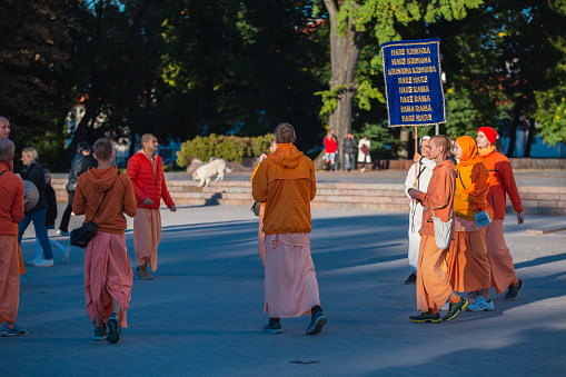 Vilnius, Lithuania - September 24, 2022:  A group of Hare Krishnas on a city street in orange clothes