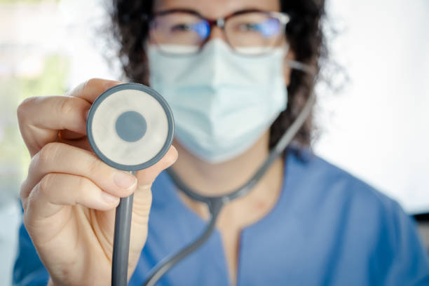nurse or sanitary auscultating with a stethoscope in front of the camera stock photo