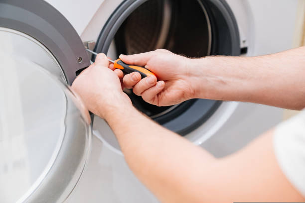 istock a man repairs a washing machine. repairman 1429272119