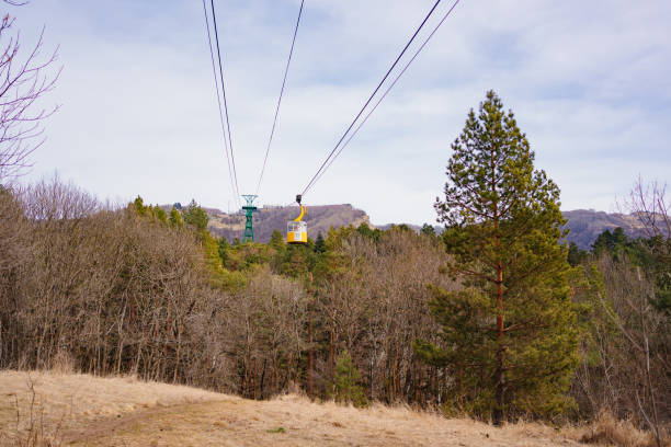 yellow funicular car with passengers moves by cableway. a vehicle with a rope traction for transporting people or goods in wagons for a short distance along a steep route, in the mountains.