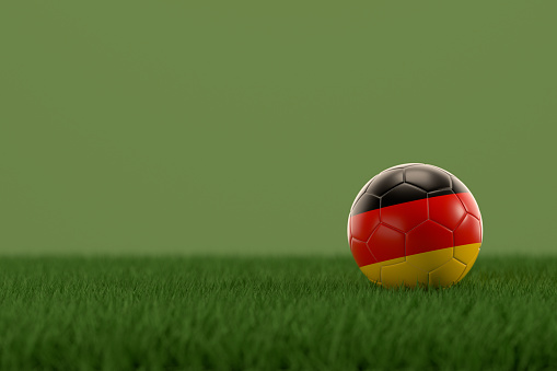 3d rendering of soccer ball with Germany flag on a grass field.