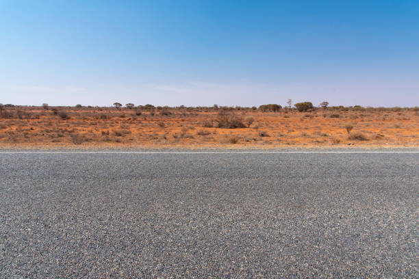 The road view with red dirt at the background and blue sky at outback rural of New South wales, Australia.