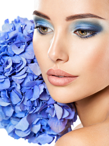 Makeup Face Flower Blue Woman Fashion. Closeup face of young beautiful woman with a blue makeup of eyes
