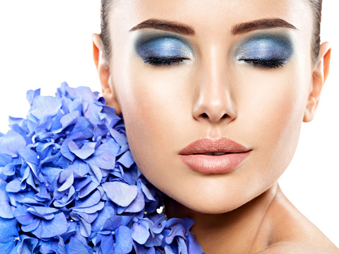 Makeup Face Flower Blue Woman Fashion. Closeup face of young beautiful woman with a blue makeup of eyes.   - isolated on white background