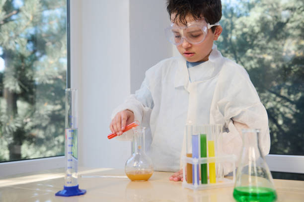 istock Elementary student boy conducting a chemical experiment, holding test tube in hands in science class .Education concept 1429282244