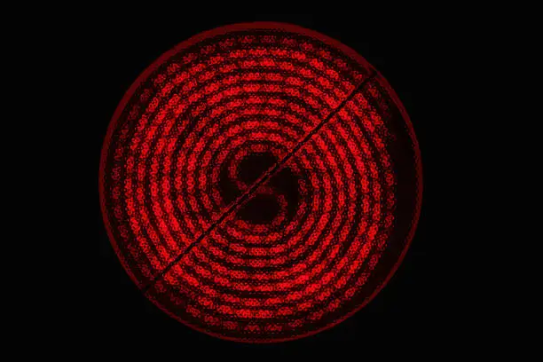 Glowing burner of the electric hotplate on black background