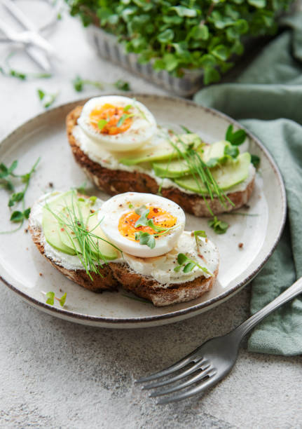 istock Bread toast, boiled eggs, avocado slice, microgreens on a plate 1429286517