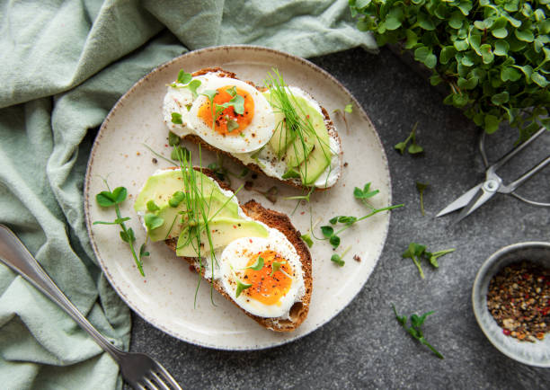istock Bread toast, boiled eggs, avocado slice, microgreens on a plate 1429286536