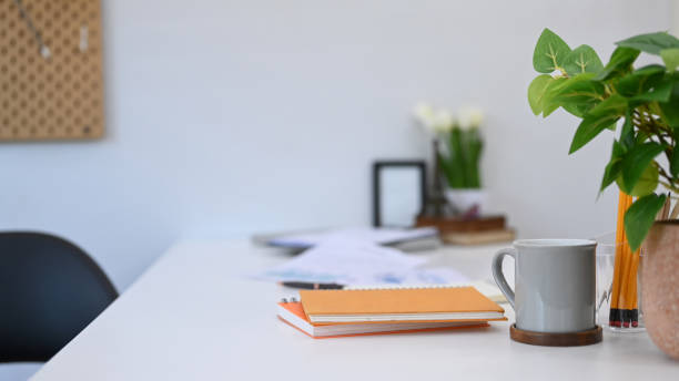 istock Home office desk with notebooks, cup of coffee, document and houseplant. 1429288475