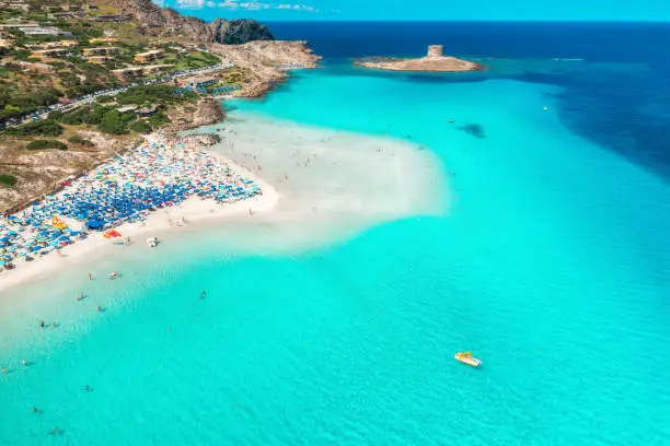 Top view of beautiful seascape. Aerial view of the white sand popular beach La Pelosa and swimming people in transparent blue water. Sardinia, Italy