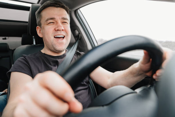 istock a happy man drives a car on the highway 1429297327