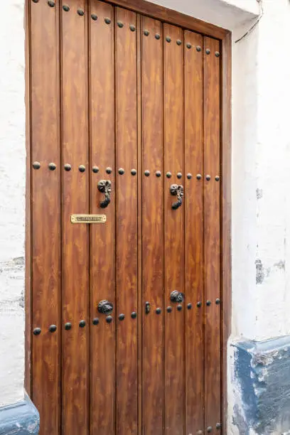 A traditional Andalusian wooden door with metal decoration.
