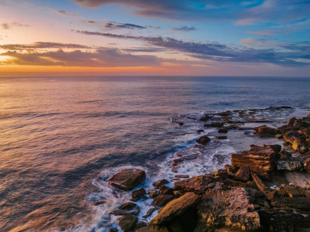 istock Peaceful sunrise over the ocean with small waves and clouds 1429302051
