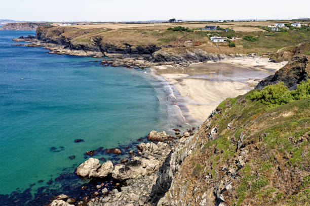 Historic harbour at Polurrian Cove - Cornwall - England Polurrian Beach, Mullion, Cornwall, England, United Kingdom. 13th of August 2022. The famous beach at Polurrian Cove on the west coast of the Lizard Peninsula in Cornwall mullion cove stock pictures, royalty-free photos & images