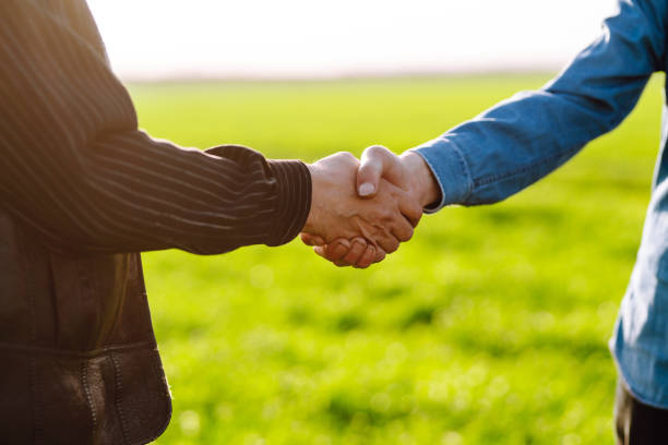 istock Handshake two farmer on the background of a field. 1429309362