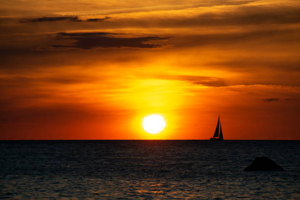 istock Sunset over the sea with a sailing ship on the horizon 1429312380