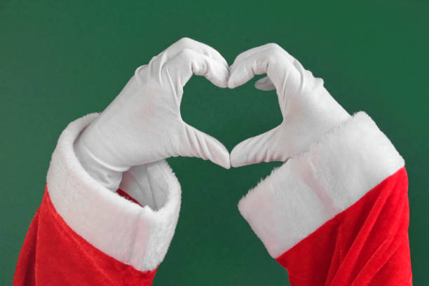 santa claus dos manos haciendo gesto en forma de corazón aislado sobre fondo verde. cerrar. signo de amor, aprobación. felicidades navideñas. gustar. pantalla chroma key. las manos enguantadas blancas forman un corazón. - gloved hand fotografías e imágenes de stock