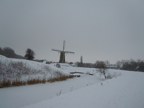 A beautiful snowy landscape with a Dutch windmill