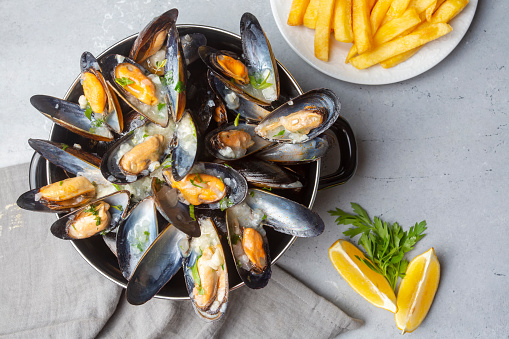 Delicious seafood mussels with parsley sauce and lemon. Delicious steamed mussels.
