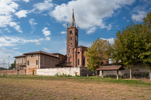Villafranca Piemonte, Turin, Piedmont, Italy - September 23, 2022: the Parish of Santi Maria Maddalena e Stefano with the church and the neo-gothic bell tower seen from the countryside