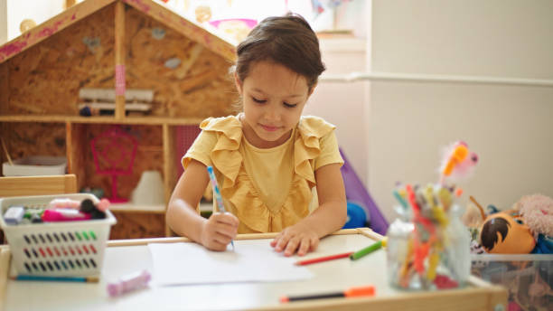 istock Little girl drawing while sitting at the table in her room 1429326042