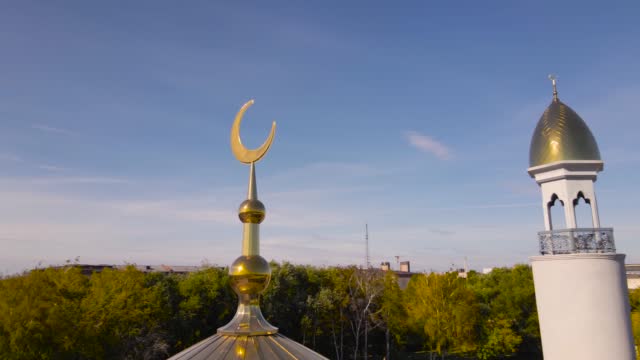 A Muslim golden dome with a crescent moon on the mosque. Minaret against the sky. Arab day. Islamic symbols of religion. Faith in Allah. Crescent moon at the top of the mosque