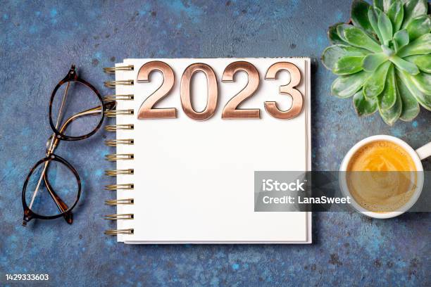 New Year Goals 2023 On Desk 2023 Resolutions List With Notebook Coffee Cup And Cristmas Tree On Blue Table Resolutions Plan Goals Action Checklist Concept New Year 2023 Template Stock Photo - Download Image Now