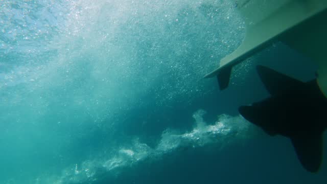 slow-motion close up of boat propeller spinning underwater producing air bubbles wake from engine