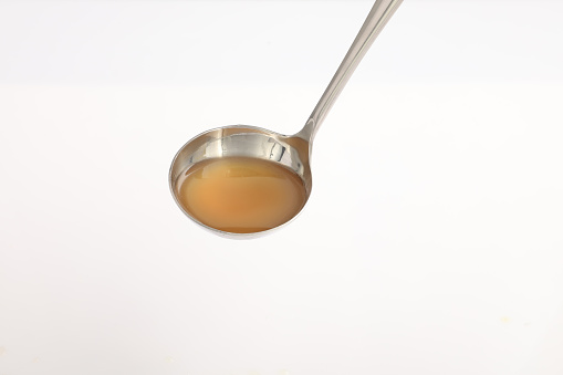 spoon isolated on white background. chicken stock on spoon.