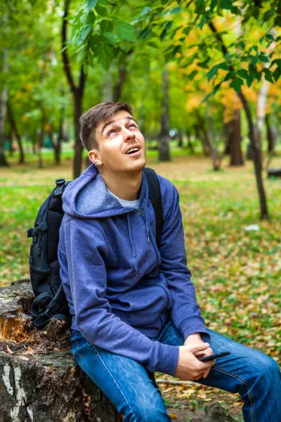 Happy Young Man in the Autumn Forest Alone