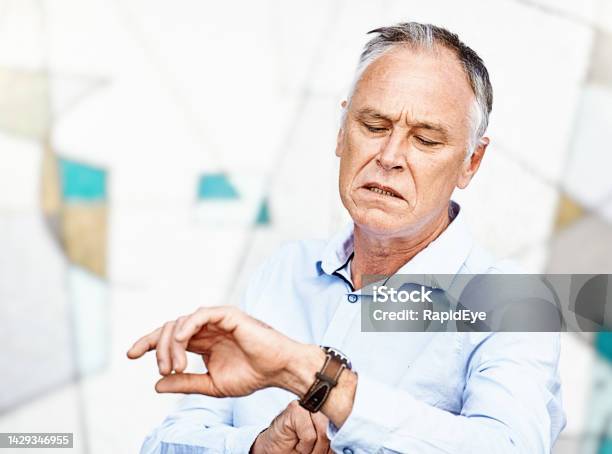 Youre Late Irritated Middleaged Man Checks The Time On His Wristwatch Stock Photo - Download Image Now