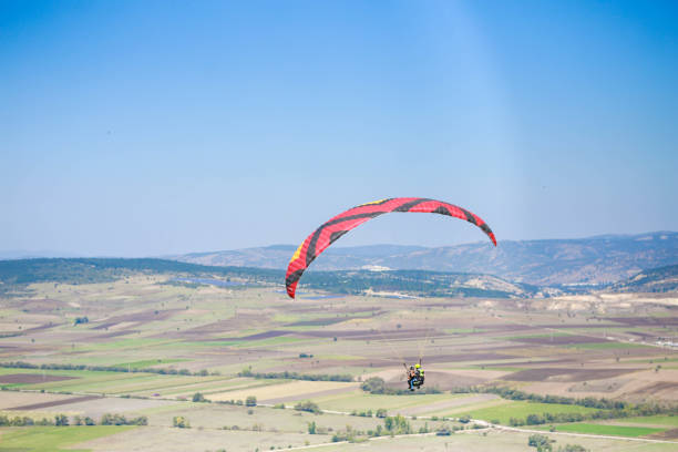 A man paragliding in the blue sky