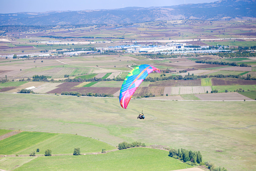 Young man flying with colorful paraglider. extreme sport