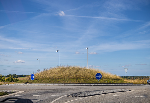 Zealand, Denmark - September 4th 2022: Roundabout under a blue sky with traces of jet planes. Roundabouts are a very popular way to regulate the traffic outside the bigger cities in Denmark