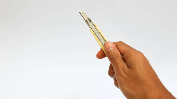 흰색 배경에 고립 된 노란색 문구 칼을 들고있는 손 - switchblade 뉴스 사진 이미지